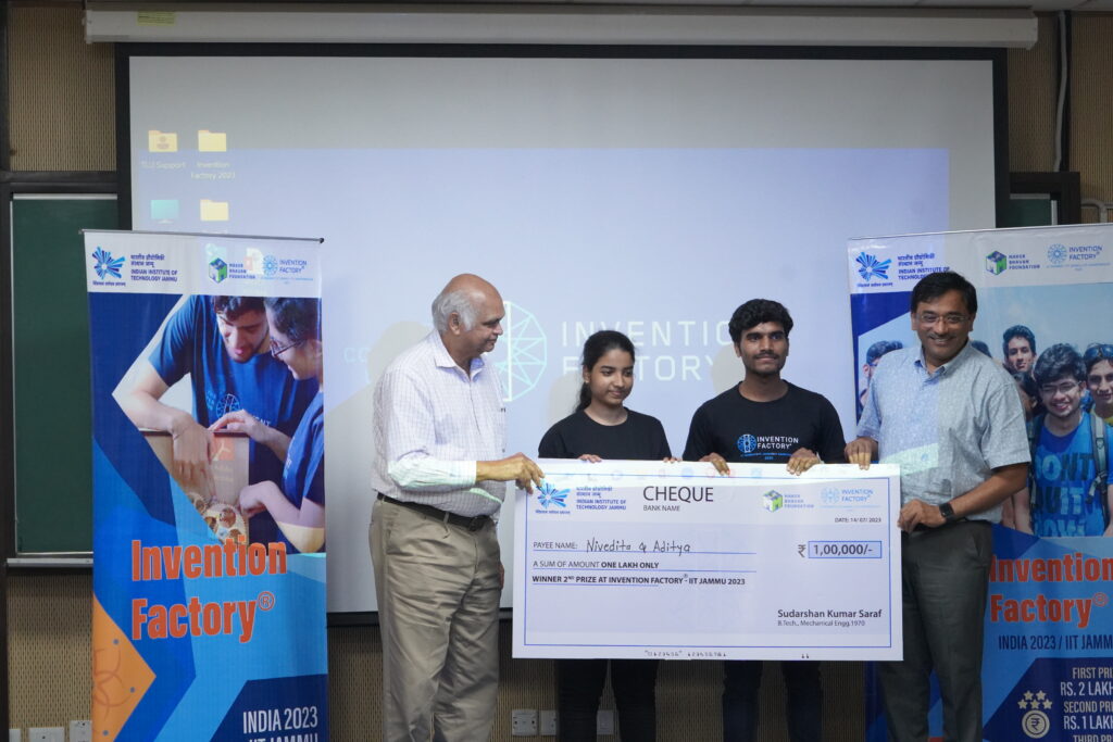 Aditya and Nivedita holding a cheque for 1 lakh rupees. Students declared winners of Invention Factory